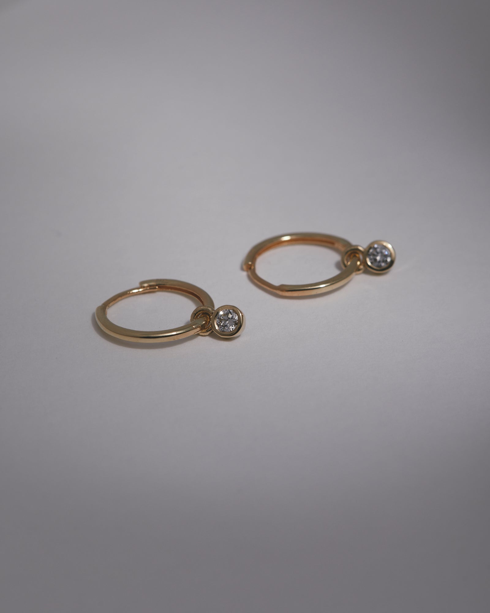 Small hinged hoops with diamond charms