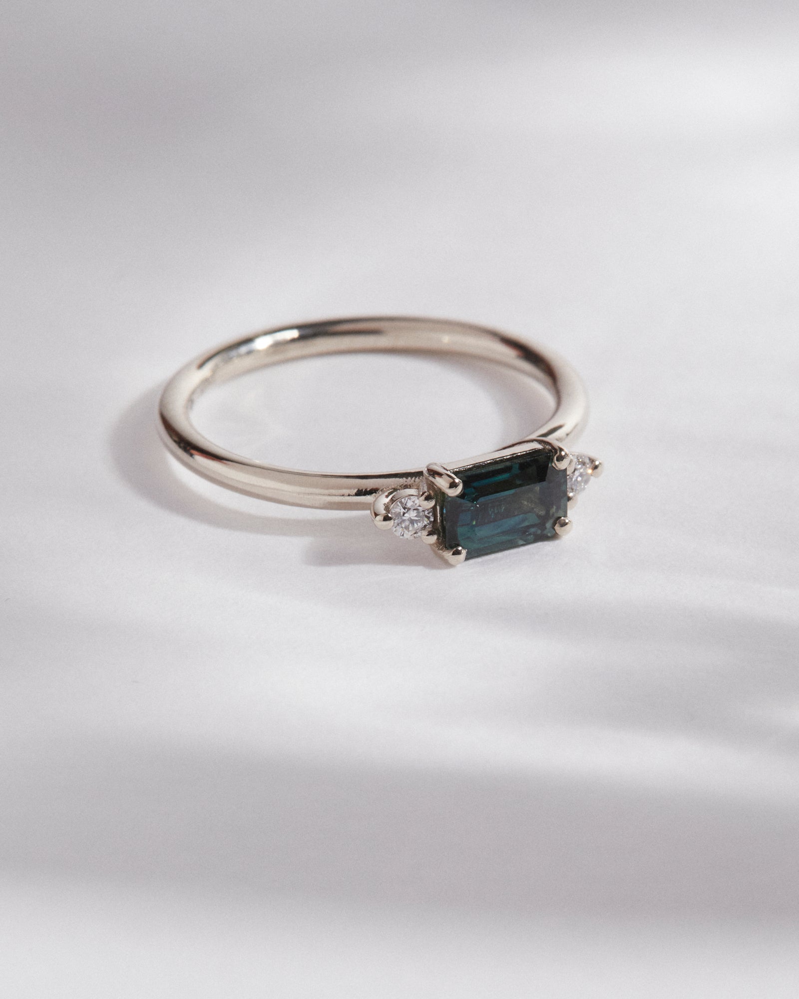 0.71ct emerald cut teal sapphire trilogy.